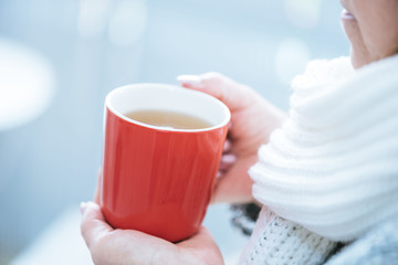 Hand of woman holding a mug of hot tea