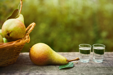Ripe pear and shot glass with brandy