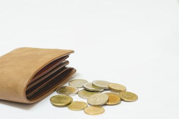 brown leather wallet on white background with many coin put in front of. wealth, saving, money, finance and investment concept.