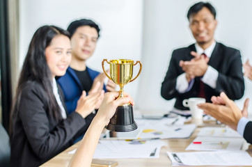 winning business team gold trophy , business team happy consent and successful business team rewarded for in the office