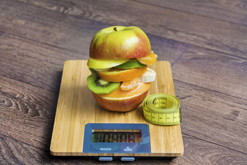 Creative Healthy Apple Burger with Fruits on a Kitchen Scale .Healthy Eating Concept