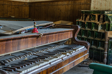 altes klavier und kachelofen in waldhaus