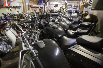 A lot of motorbikes standing in row in warm storage for overwintering in northern country