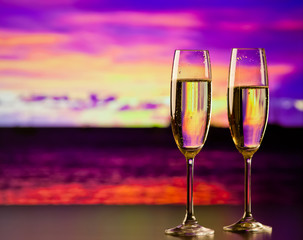 two champagne glasses at sunset