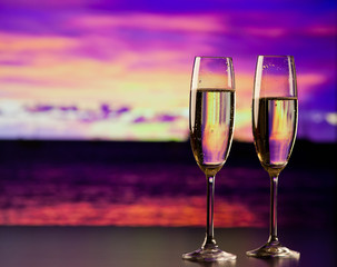 two champagne glasses at sunset