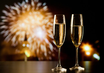 two champagne glasses against holiday lights and fireworks - new year celebration © Melinda Nagy