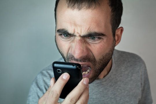 Angry caucasian man with phone.