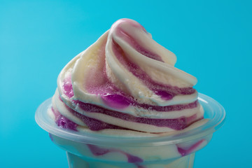 cup of strawberry flavor ice cream close up on blue background