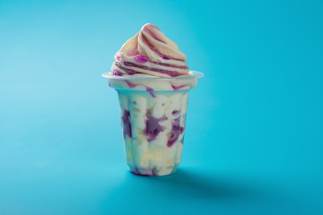 cup of strawberry flavor ice cream on blue background