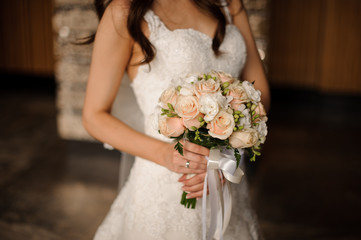 Obraz na płótnie Canvas Bride in a lovely white dress holding a wedding bouquet