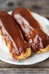 Delicious eclairs with chocolate frosting on the table 