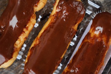 Delicious eclairs with chocolate frosting on the table 