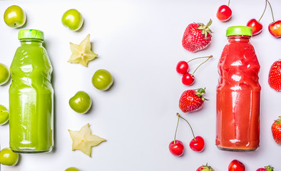 Obraz premium appetizing healthy smoothies from carambola and green plum, strawberries and sweet cherries in glass bottles on a white wooden rustic background, top view