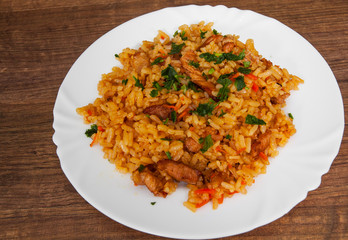 Rice with Vegetables and Meat in a plate on wooden table.