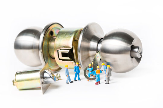 Selective Focus Of Miniature Engineer And Worker Prepare Stainless Steel Round Ball Door Knob Components On White Background As Locksmith, Business And Industrial Concept.