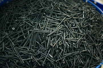Screws in the barrel in the constructiob market shop background. Construction background.