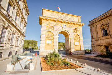 Fototapeta na wymiar Street view with famous Triumphal Arch on the Foch boulevard during the morning light in Montpellier city in Occitanie region of France