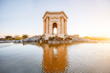 View on the water tower in Peyrou garden with beautiful water reflection during the evening light in Montpellier city in southern France - obrazy, fototapety, plakaty