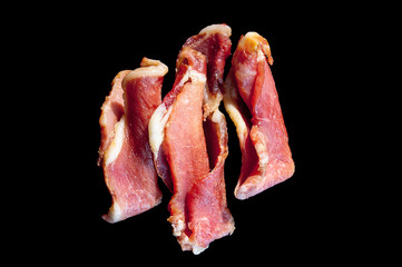 Piggy jerky isolated on black. Three in a row