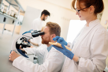Young scientist looking through microscope in laboratory