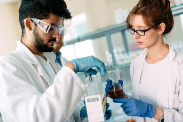 Obraz premium Young students of chemistry working in laboratory