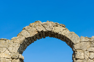 Stone arch against a blue sky.