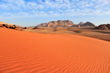 Wadi Rum desert in Jordan. Big area with smooth untouched red sand and mountains at the background...