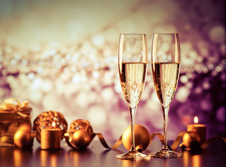 two champagne glasses against holiday lights and fireworks - new year celebration