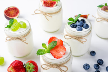 Fresh yogurt with berries in glass jars. Dairy products. Healthy food, dieting and breakfast concept