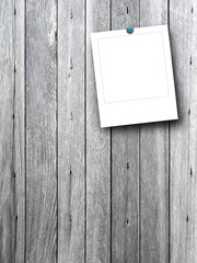 Blank square photo frame with pin on gray wooden boards background