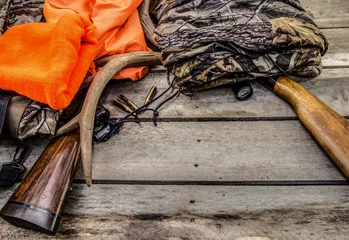 Photo sur Plexiglas Chasser Fond de chasse au cerf. Fusils de chasse, portée, bois, balles et vêtements de chasse sur un fond en bois rustique avec espace de copie.