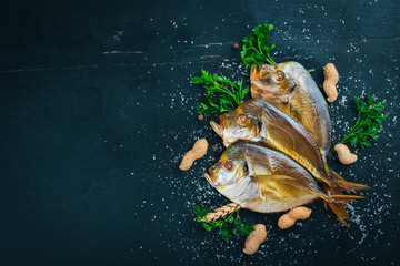Smoked fish, Vomer. Seafood. On a wooden background. Top view. Free space for your text.