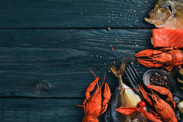 Seafood. Fish Vomer, lobster, salmon. On a wooden background. Top view. Free space for text.