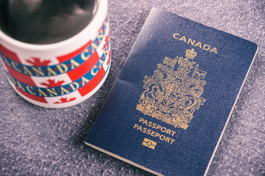 Canadian Passport Sitting Next To A Canada Mug