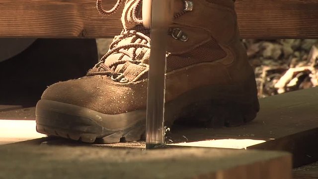 Person sawing in boots