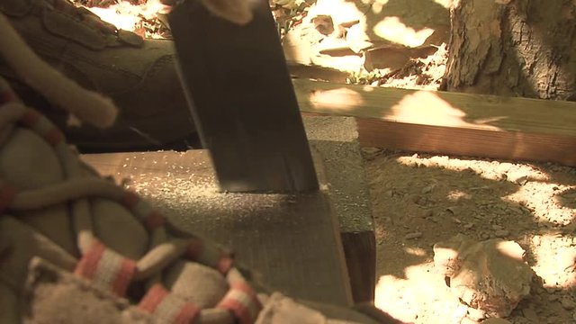 Someone with boots on wood sawing