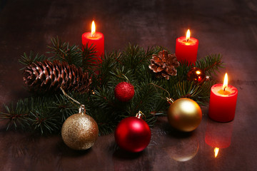 Christmas decoration with colorful balls, candles and christmas tree on a wooden desktop.