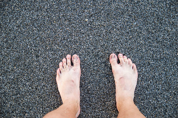 Legs against the background of sea pebbles