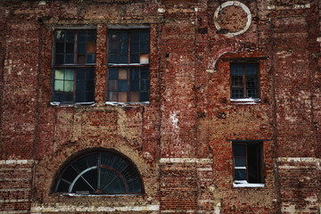 An old, vintage brick building with unusual windows. Background, texture of a brick wall