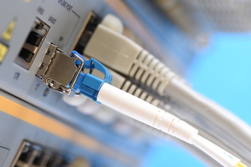 Optical fiber patch cord and network cables connected to switch in datacenter, with selective focus