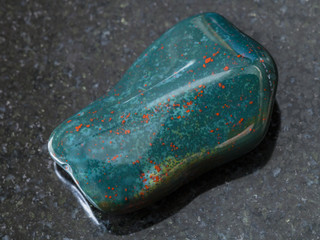 polished green Heliotrope gem stone on dark
