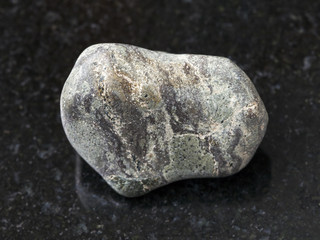 tumbled Suevite stone on dark background