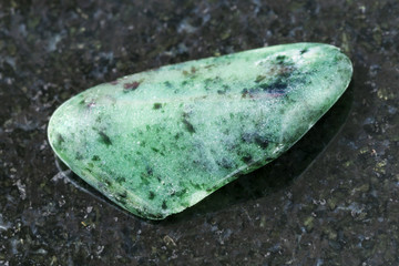 tumbled zoisite gemstone on dark background