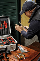 Carpenter working the replacement of the lock of a door.