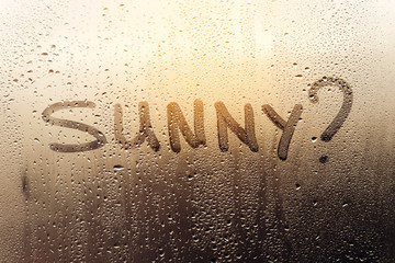 Rainy weather, the inscription on the sweaty glass - Sunny?