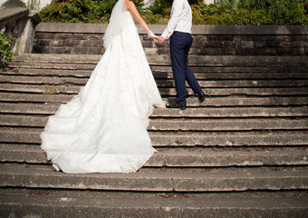 Obraz na płótnie Canvas Happy bride and groom at wedding walk in park