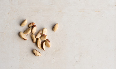 Fototapeta na wymiar High angle view of brazil nuts on limestone background with copy space