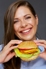 Smiling woman holding tasty burger.