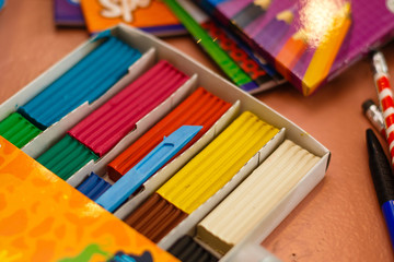 Naklejka premium Top view of a white plastic box with colorful plasticine bars greenish blue yellow red 
