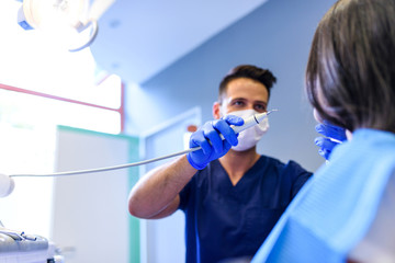 Fototapeta na wymiar A young Dentist treating a female Patient in the dental studio